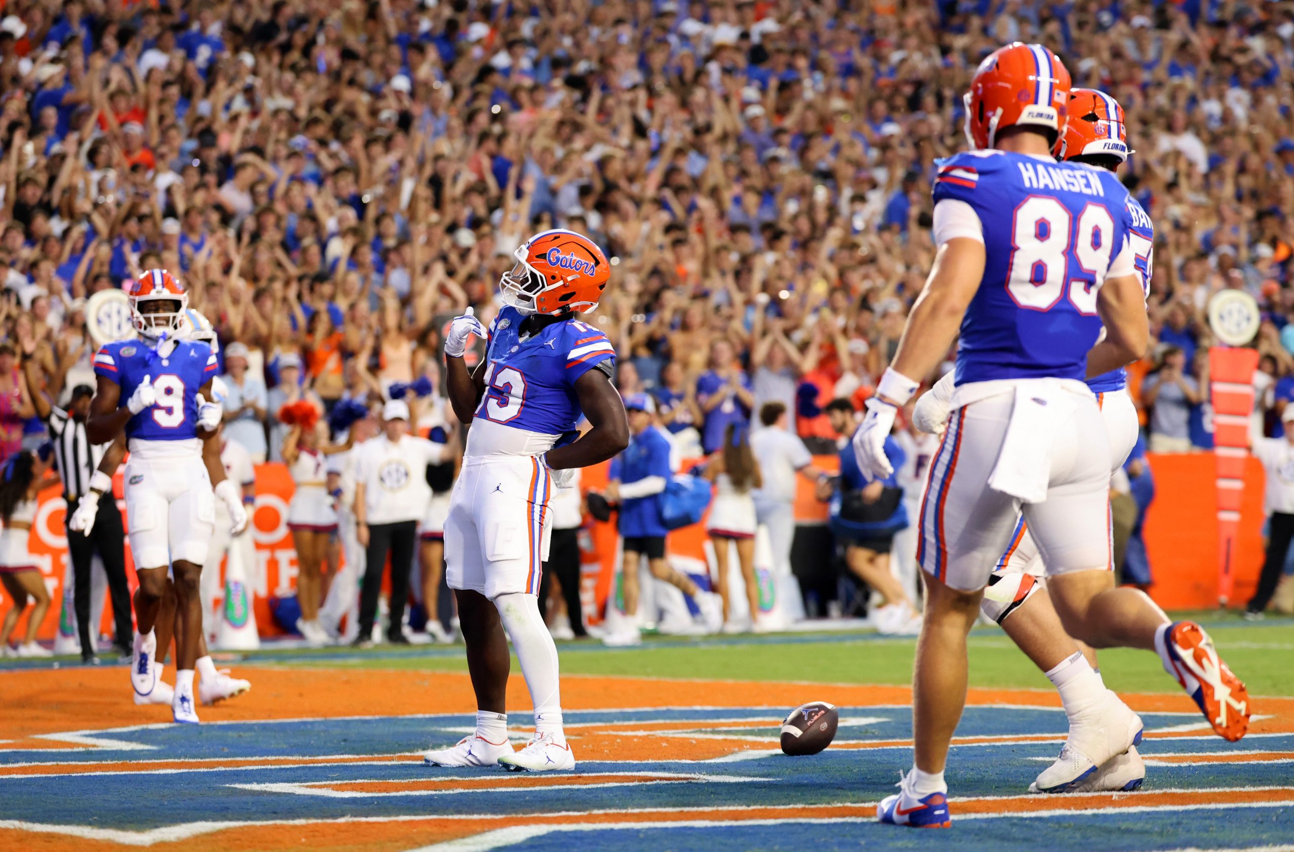 Florida football players celebrating in the end zone in front of a cheering crowd.